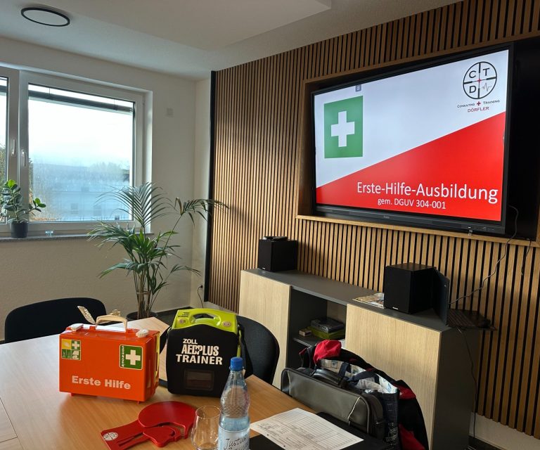 Ausbildung Consulting + Training Dörfler Schulungsraum mit Gesundheitsmaterialien und Monitor für Erste-Hilfe-Ausbildung.